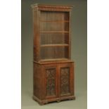 A Victorian oak bookcase on cupboard, in two sections,