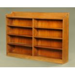 An Edwardian walnut open bookcase, with rear pediment and two series of adjustable shelves.