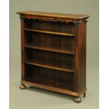 An Edwardian oak open bookcase, with a series of adjustable shelves and raised on bun feet.