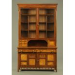 An Arts and Crafts walnut bookcase in two sections,