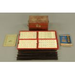 A vintage bone mounted mahjong set, complete with cloth trays and instructions.