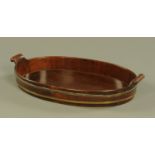 A George III mahogany oval brass bound tray, with scroll carrying handle to either side.
