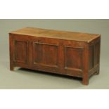 An 18th century oak bedding box, with three panelled front and raised on stile feet. Width 135 cm.