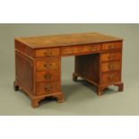 A Georgian style mahogany pedestal desk, with brown tooled leather writing surface,