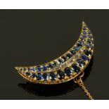A large late 19th/early 20th century sapphire and diamond crescent shaped brooch, with safety chain.