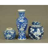 A Chinese blue and white prunus patterned vase, together with two ginger jars, tallest 25 cm.