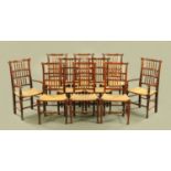 A set of ten oak spindle backed rush seated dining chairs raised on turned legs and stretchers (see