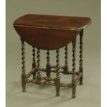 An early 20th century oak small twin drop flap oval gate leg occasional table,