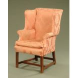 A George III style mahogany wing easy chair, upholstered in pink foliate patterned material.