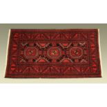 A red ground Persian design rug,
