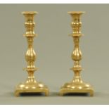 A pair of 19th century heavy brass candlesticks, with knopped stems and square bases. Height 20 cm.