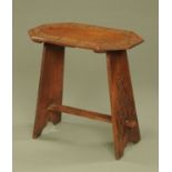 An Arts & Crafts oak side table, with canted angles and blind fretwork carved. Width 71 cm.