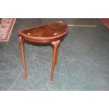 Queen Anne style walnut demi-lune table with glass top