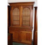 Large Victorian oak bookcase with arched glazed doors and adjustable shelves,