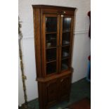 Oak freestanding glazed corner cupboard with wooden shelves and cupboard space below