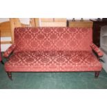 Large floral upholstered Victorian settee raised on castors,