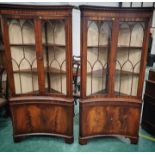 Pair of flame mahogany concave Chapman Siesta corner display cabinets,