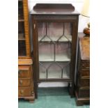 Glazed china display cabinet with fixed wooden shelves, key decoration, and upstand back,