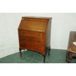 Mahogany bureau opening to a fitted interior with maroon tooled leather insert and drawers