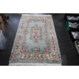 Tasselled oriental floral patterned rug on blue ground,