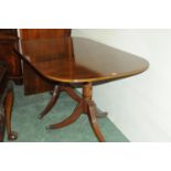 Modern mahogany dining table with leaf raised on turned columns with hairy paw feet