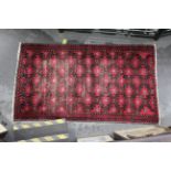 Red patterned tasseled rug,