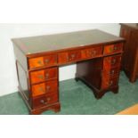 Modern mahogany kneehole desk with green tooled leather top