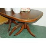 Mahogany dining table with leaf raised on pedestals with three legs and hairy paw feet