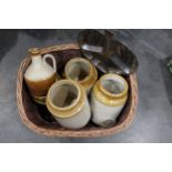 Basket of stainless steel nut dish, four stoneware storage jars, jugs with stoppers, brass bell,
