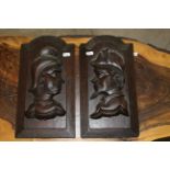 A pair of Victorian carved and arched fielded panels, the centres carved with figural busts,