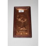 A small embossed copper rectangular plaque, probably African, depicting A lady wielding an axe,