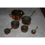 A set of five copper graduated sauce pans, together with a lidded copper pan.