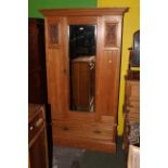 An Edwardian satinwood mirror door wardrobe with moulded cornice above the central bevelled