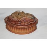 A 19th century pottery oval hare pie dish, the lid model with hares heads with glass eyes.
