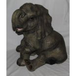 A resin model of a seated elephant calf, 42 cm high.