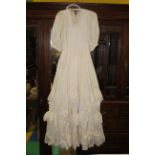A vintage ivory coloured satin ball gown or bridesmaid dress, mostly likely for a younger female,