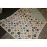 A modern machine stitched patchwork coverlet comprising various hexagonal patches, 149 cm x 206 cm.