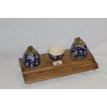 A Victorian oak desk stand with two cobalt blue and prunus decorated pottery inkwells and a ditto