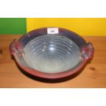 A modern Irish art pottery bowl with stylised pierced handles and ribbed interior,