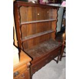 An early 20th century oak dresser with open rack,