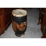 An African painted wood drum with animal skin top, 33 cm diameter x 62 cm high.
