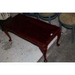 A modern reproduction figured mahogany coffee table of shaped rectangular form on cabriole style