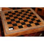 A moulded and stained leather chessboard,
