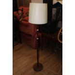 A mid century teak standard lamp of turned cylindrical form,