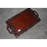 A Chinese carved and stained hardwood rectangular two handled tray,