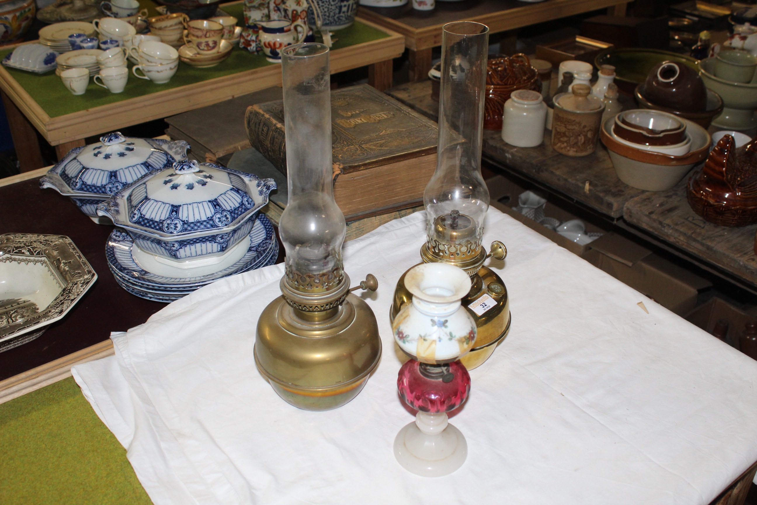 Two brass table oil lamps with chimneys, each 45 cm high including the chimneys,