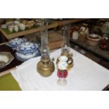 Two brass table oil lamps with chimneys, each 45 cm high including the chimneys,