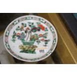 An early 20th century Chinese Famille Vert porcelain circular saucer decorated with a basket of