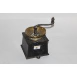 A 19th century black painted cast iron and brass rimmed coffee grinder with drawer,