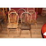 A group of thirteen Ercol and Ercol style hooped stick back chairs in light and stained wood.